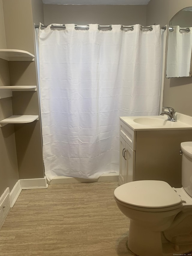 bathroom featuring toilet, hardwood / wood-style floors, vanity, and curtained shower