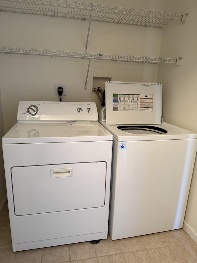 laundry room featuring light tile patterned floors and washing machine and dryer