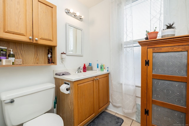 bathroom featuring toilet, tile patterned flooring, a wealth of natural light, and vanity