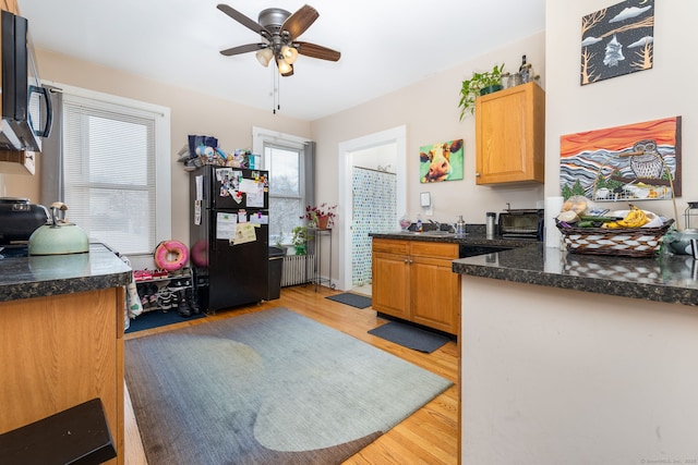 kitchen with ceiling fan, black refrigerator, sink, and light wood-type flooring