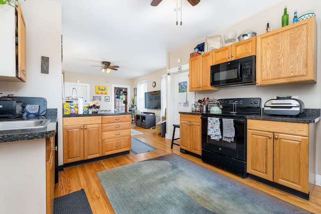 kitchen with kitchen peninsula, ceiling fan, sink, light hardwood / wood-style floors, and black appliances