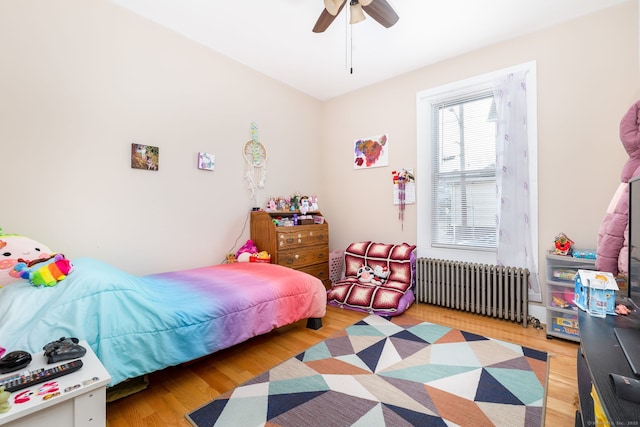 bedroom featuring ceiling fan, light hardwood / wood-style floors, and radiator