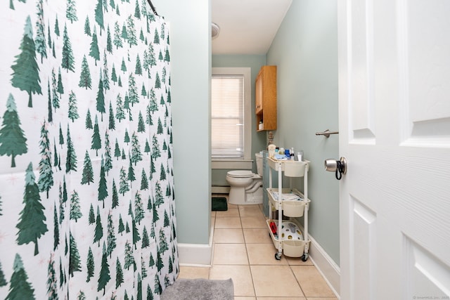 bathroom with a baseboard heating unit, toilet, and tile patterned flooring