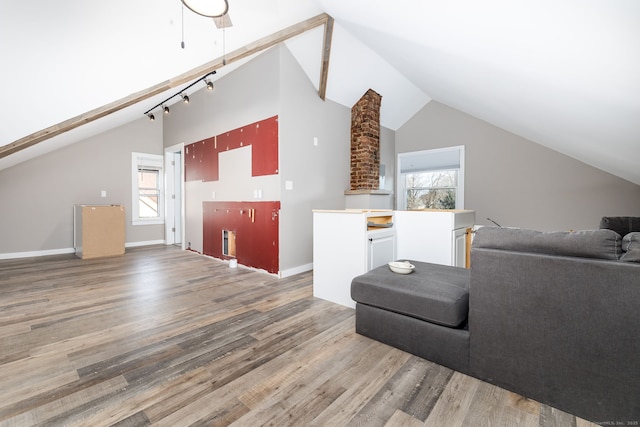 living room featuring a healthy amount of sunlight, lofted ceiling, and dark hardwood / wood-style flooring