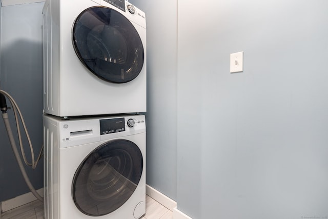 clothes washing area featuring stacked washing maching and dryer