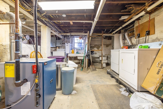 basement with washing machine and dryer, electric panel, and water heater