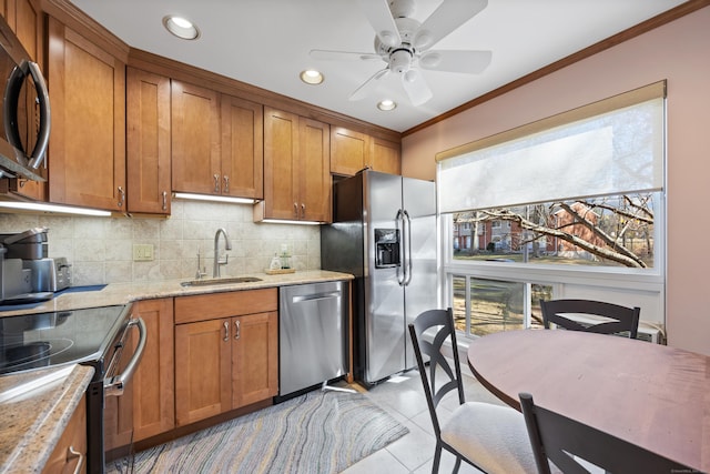 kitchen featuring stainless steel appliances, sink, light tile patterned flooring, light stone counters, and crown molding