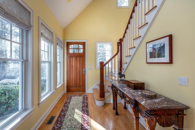 entryway with vaulted ceiling and light wood-type flooring