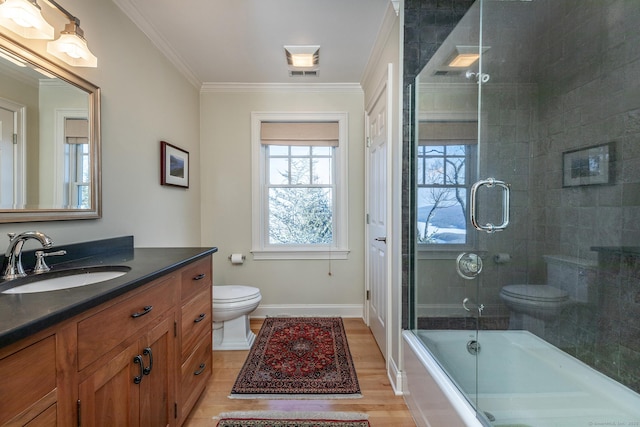 full bathroom with shower / bath combination with glass door, vanity, wood-type flooring, ornamental molding, and toilet