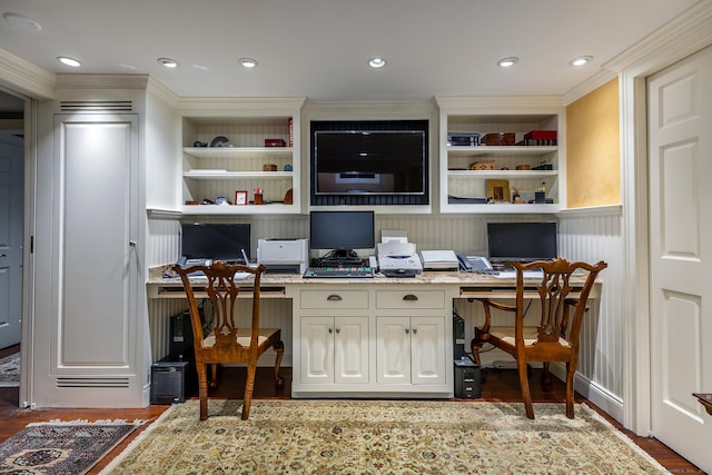 home office with crown molding, built in desk, and dark hardwood / wood-style flooring