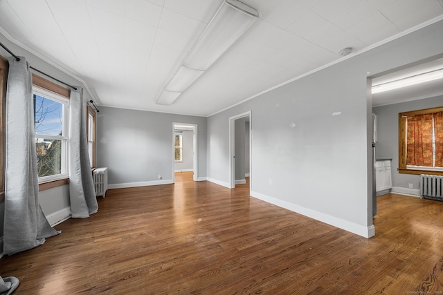 spare room featuring crown molding, radiator heating unit, and dark hardwood / wood-style floors