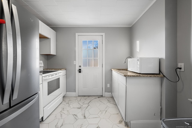 kitchen with white appliances, dark stone counters, crown molding, white cabinets, and sink