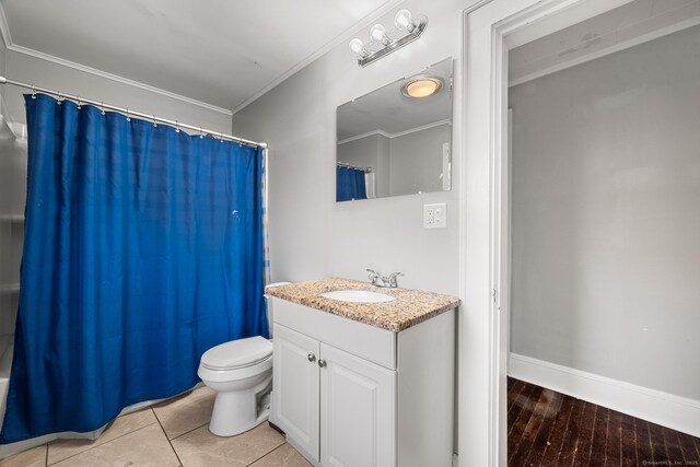 full bathroom with vanity, toilet, ornamental molding, hardwood / wood-style flooring, and shower / bath combo