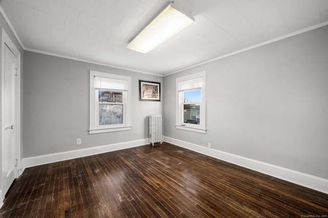 empty room featuring crown molding, dark hardwood / wood-style floors, and radiator heating unit