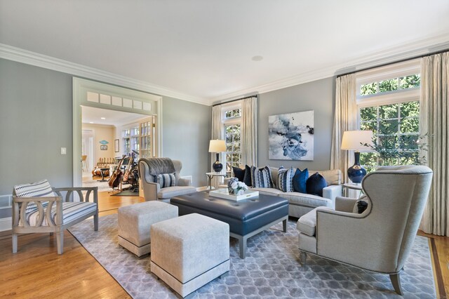 living room with a wealth of natural light, crown molding, and hardwood / wood-style flooring