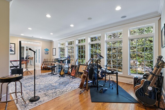 exercise area featuring crown molding and light hardwood / wood-style floors