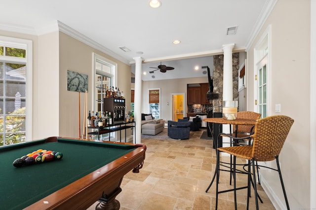 game room featuring ceiling fan, a wealth of natural light, ornate columns, and ornamental molding