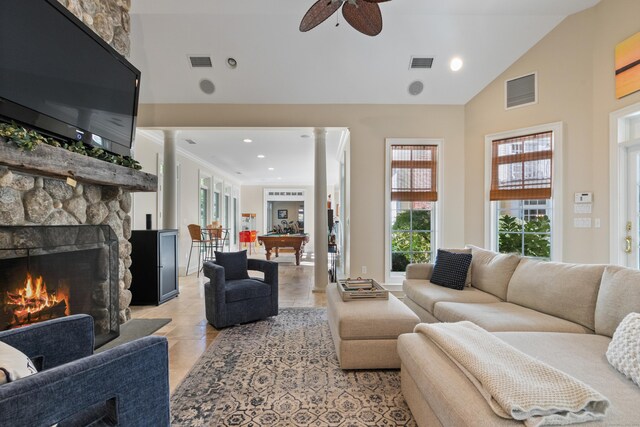 tiled living room with ceiling fan, high vaulted ceiling, a stone fireplace, and billiards