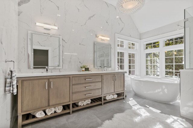 bathroom with a washtub, vanity, and vaulted ceiling