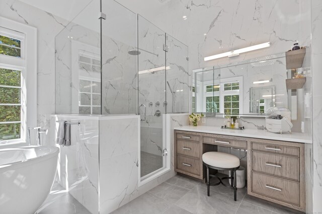 bathroom featuring a wealth of natural light, vanity, and independent shower and bath