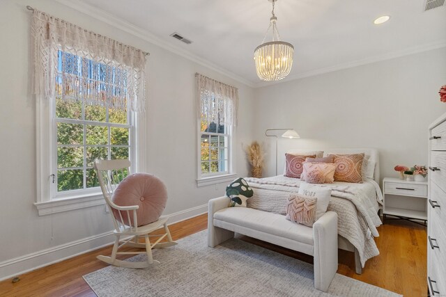 bedroom with crown molding, an inviting chandelier, and light wood-type flooring