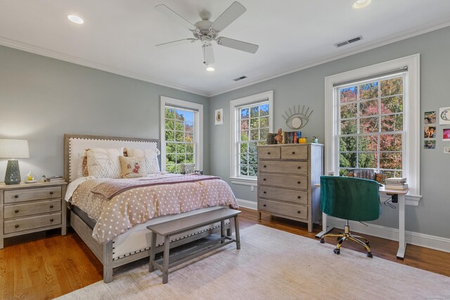 bedroom with ceiling fan, crown molding, and hardwood / wood-style flooring