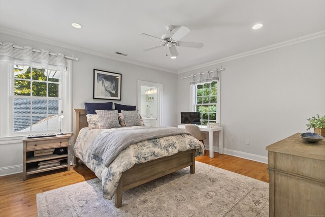 bedroom with ceiling fan, crown molding, hardwood / wood-style floors, and multiple windows