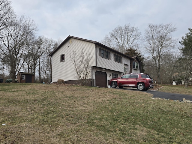 view of home's exterior featuring a lawn, a storage unit, and a garage