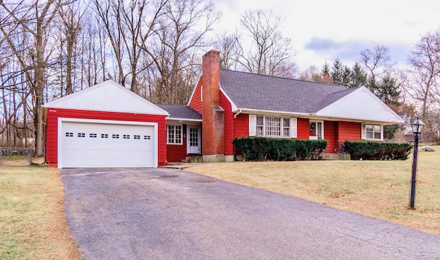 single story home featuring a garage and a front lawn