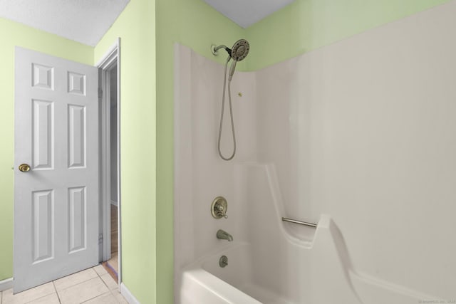 bathroom with washtub / shower combination, a textured ceiling, and tile patterned floors