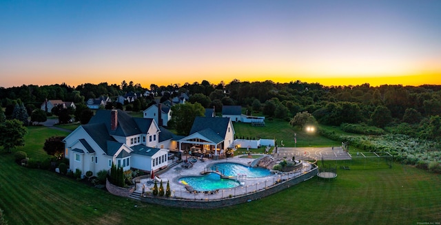 pool at dusk with a patio area