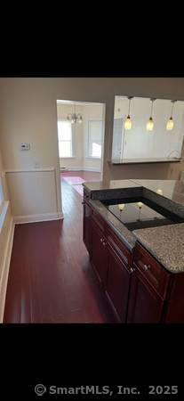 kitchen with an inviting chandelier, dark hardwood / wood-style floors, and hanging light fixtures