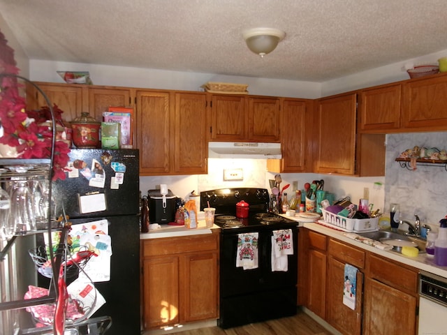 kitchen featuring light hardwood / wood-style floors, sink, a textured ceiling, and black appliances