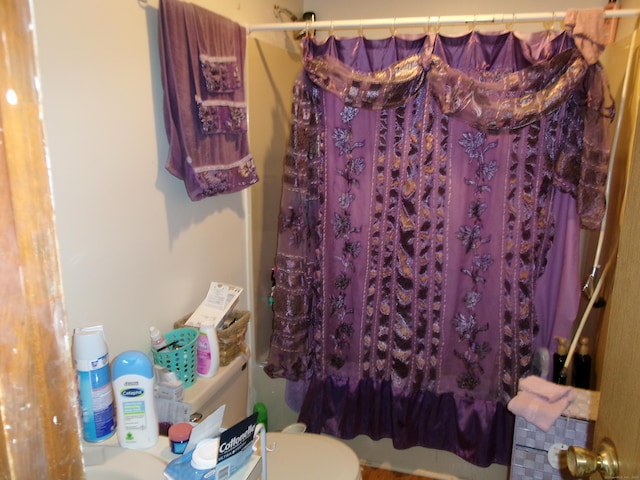 bathroom featuring shower / tub combo and toilet