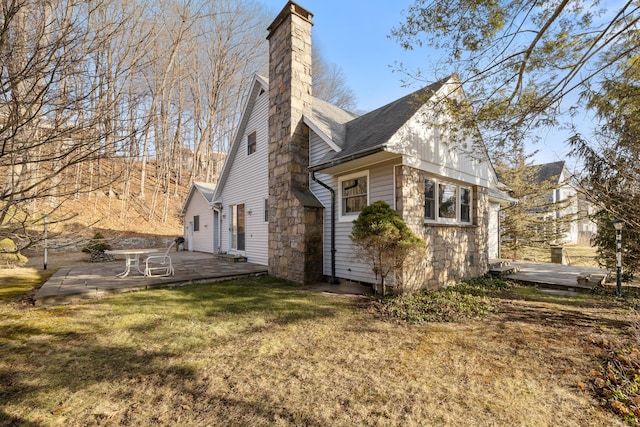 rear view of house featuring a lawn and a patio