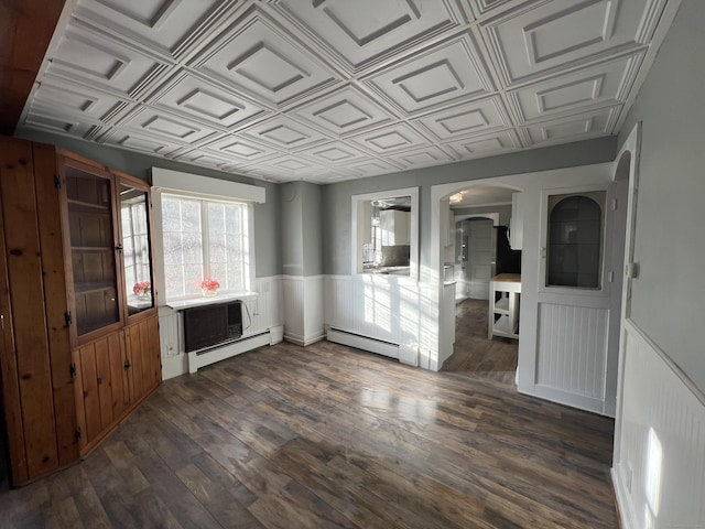 unfurnished living room with dark hardwood / wood-style flooring and a baseboard radiator