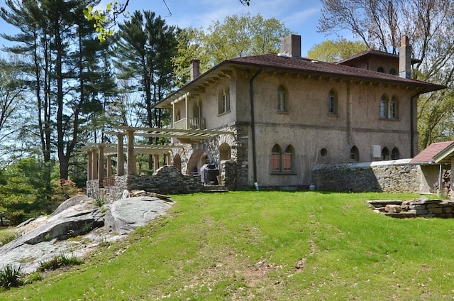 7 Old Depot Rd, Chester, CT 06412 - back of house featuring a pergola, a chimney, a lawn, and stucco siding