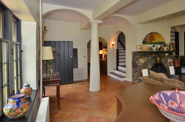 7 Old Depot Rd, Chester, CT 06412 - tiled living room with arched walkways, radiator, a fireplace, stairs, and ornate columns