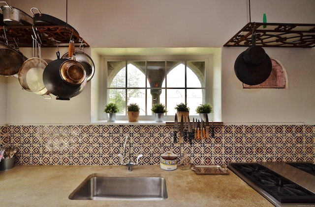 room details featuring stainless steel gas cooktop, light countertops, and a sink