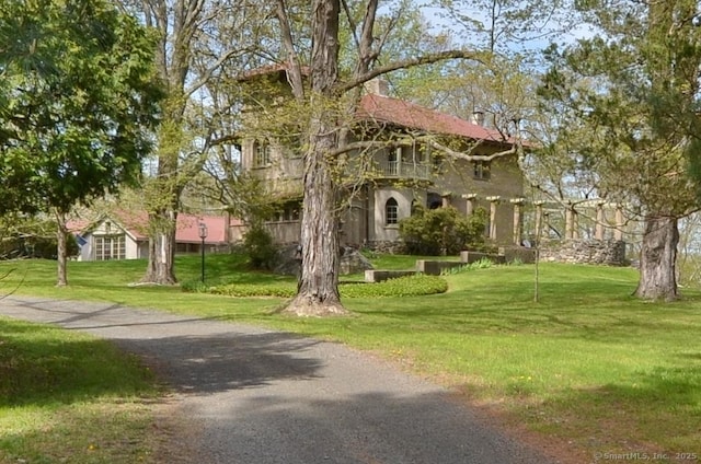 view of front of house featuring a front yard and a balcony