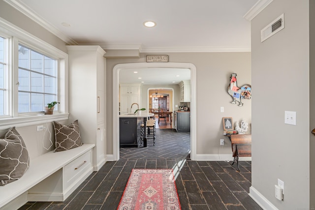 corridor with crown molding and sink