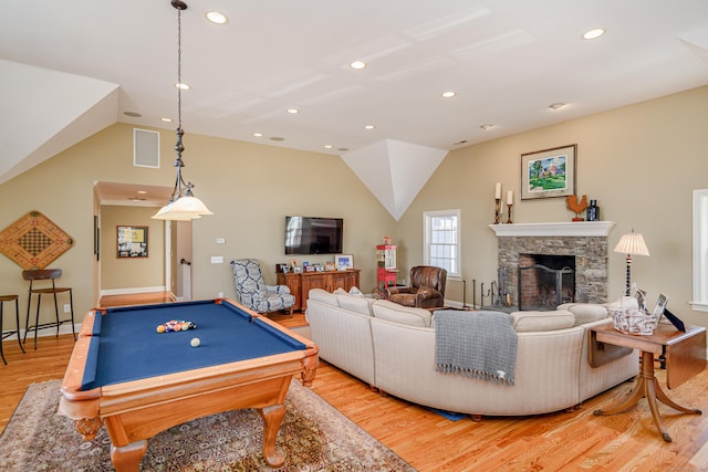 playroom featuring lofted ceiling, a stone fireplace, billiards, and light wood-type flooring