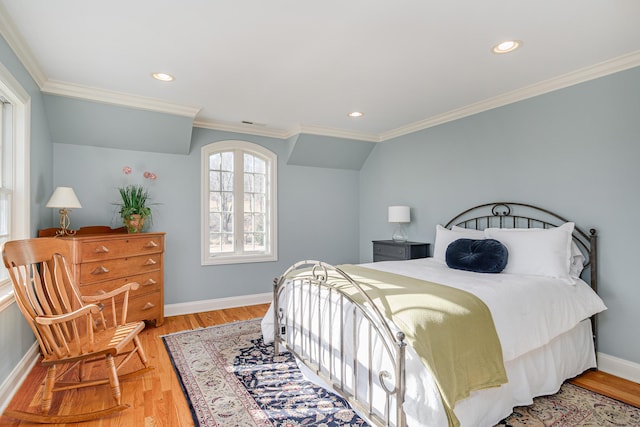 bedroom with crown molding, lofted ceiling, and light wood-type flooring