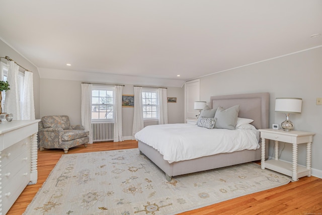 bedroom with radiator and light hardwood / wood-style flooring