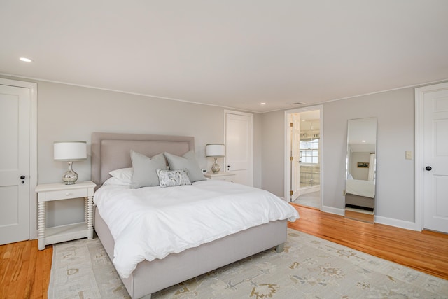 bedroom featuring light wood-type flooring and ensuite bathroom