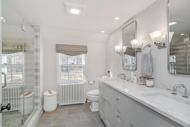 bathroom featuring lofted ceiling, radiator heating unit, vanity, toilet, and walk in shower