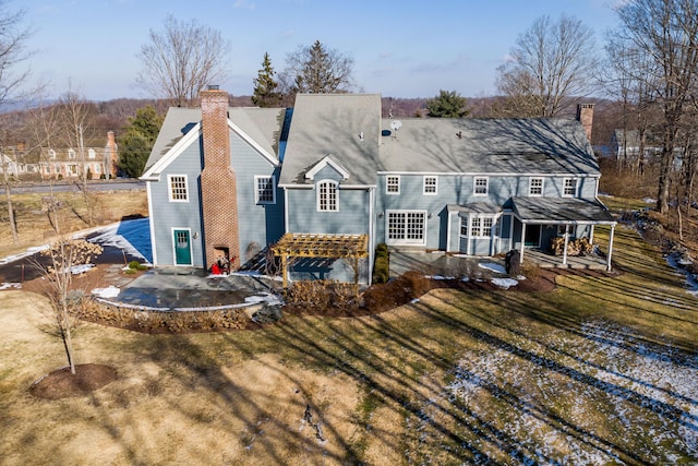 back of property with a lawn and a patio area