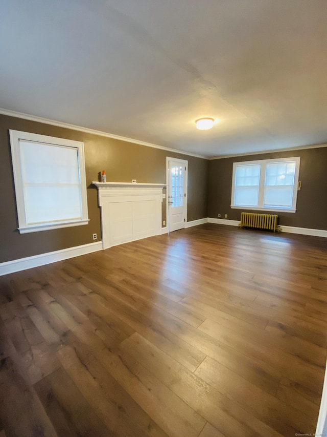 unfurnished room featuring crown molding, dark hardwood / wood-style floors, and radiator heating unit