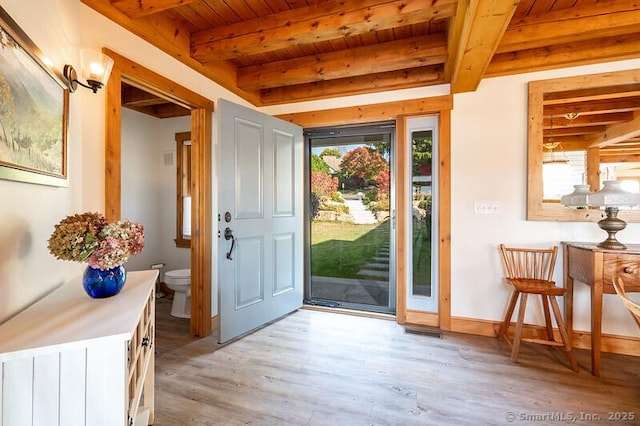 doorway with beamed ceiling, light hardwood / wood-style floors, and wooden ceiling