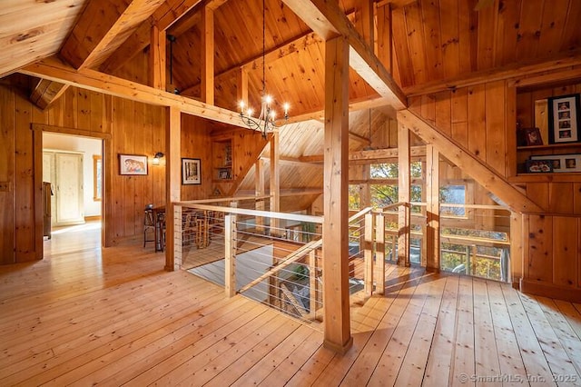 interior space with wood walls, wood finished floors, and an upstairs landing